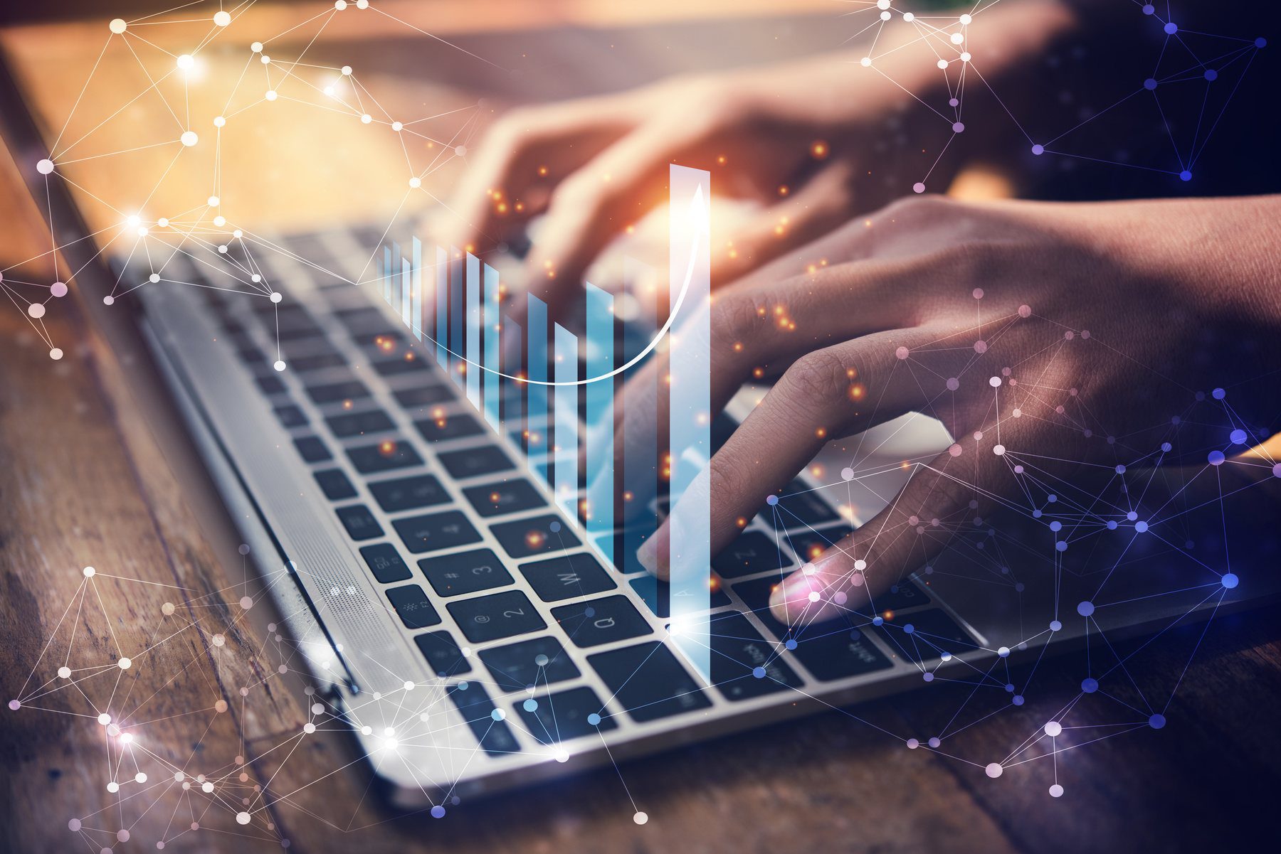 woman typing on laptop keyboard with holographic graph