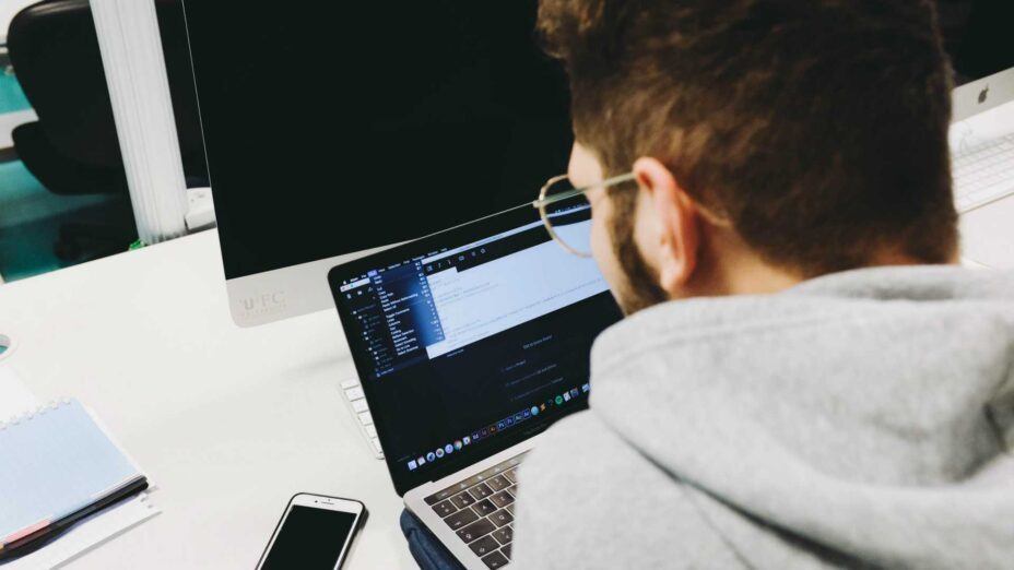 man with glasses working on his laptop
