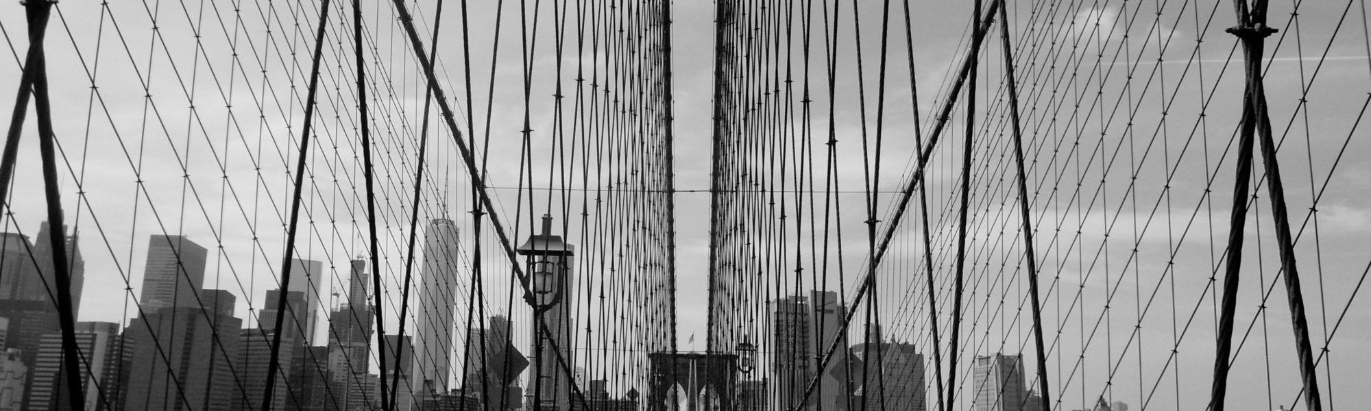 black and white photo on the middle of the brooklyn bridge
