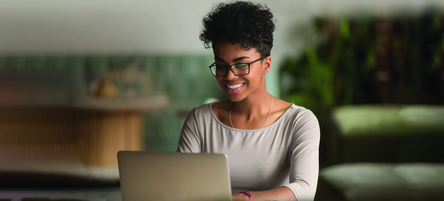 Happy african american woman using laptop work study in office