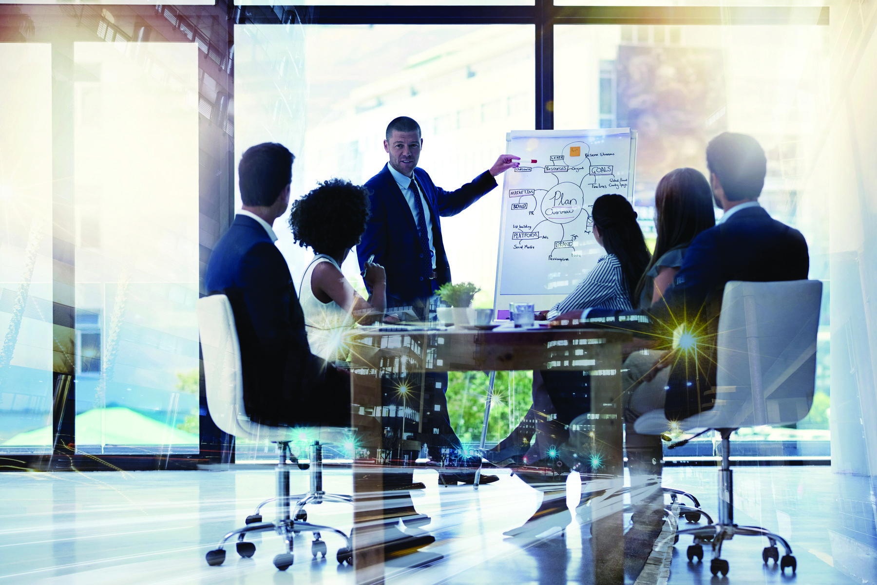 businessman presenting graphics on board to coworkers