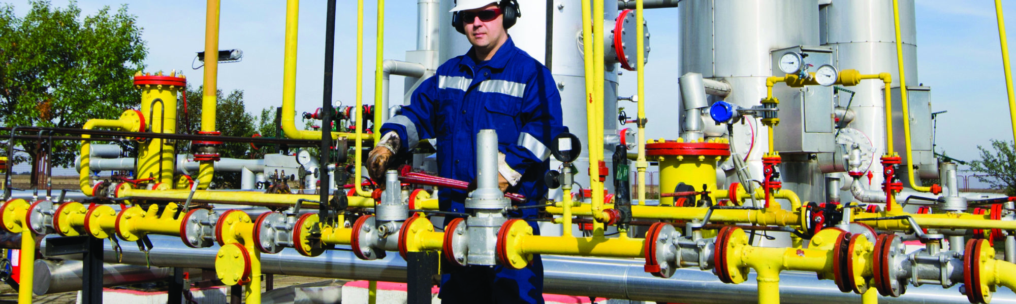 engineering technician tightening a valve on a pipe system