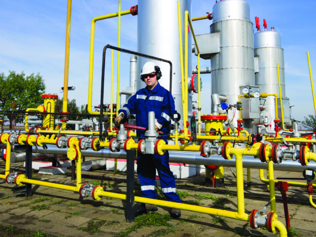 engineering technician tightening a valve on a pipe system