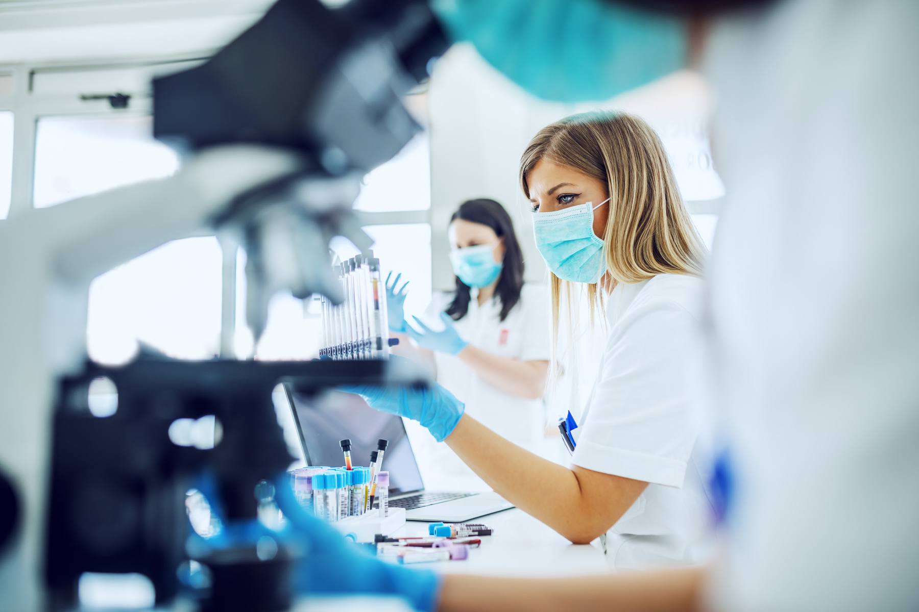 laboratory assistants using microscopes to test samples