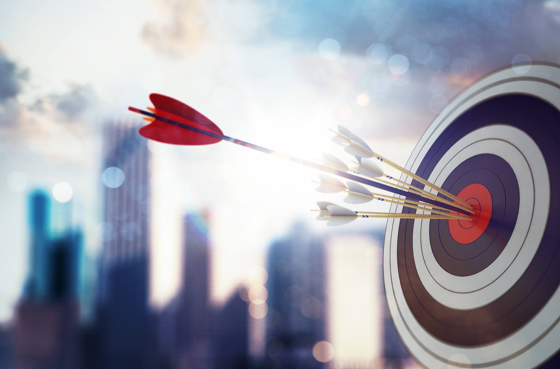 Arrow hit the center of target with modern skyscraper background. Business target achievement
