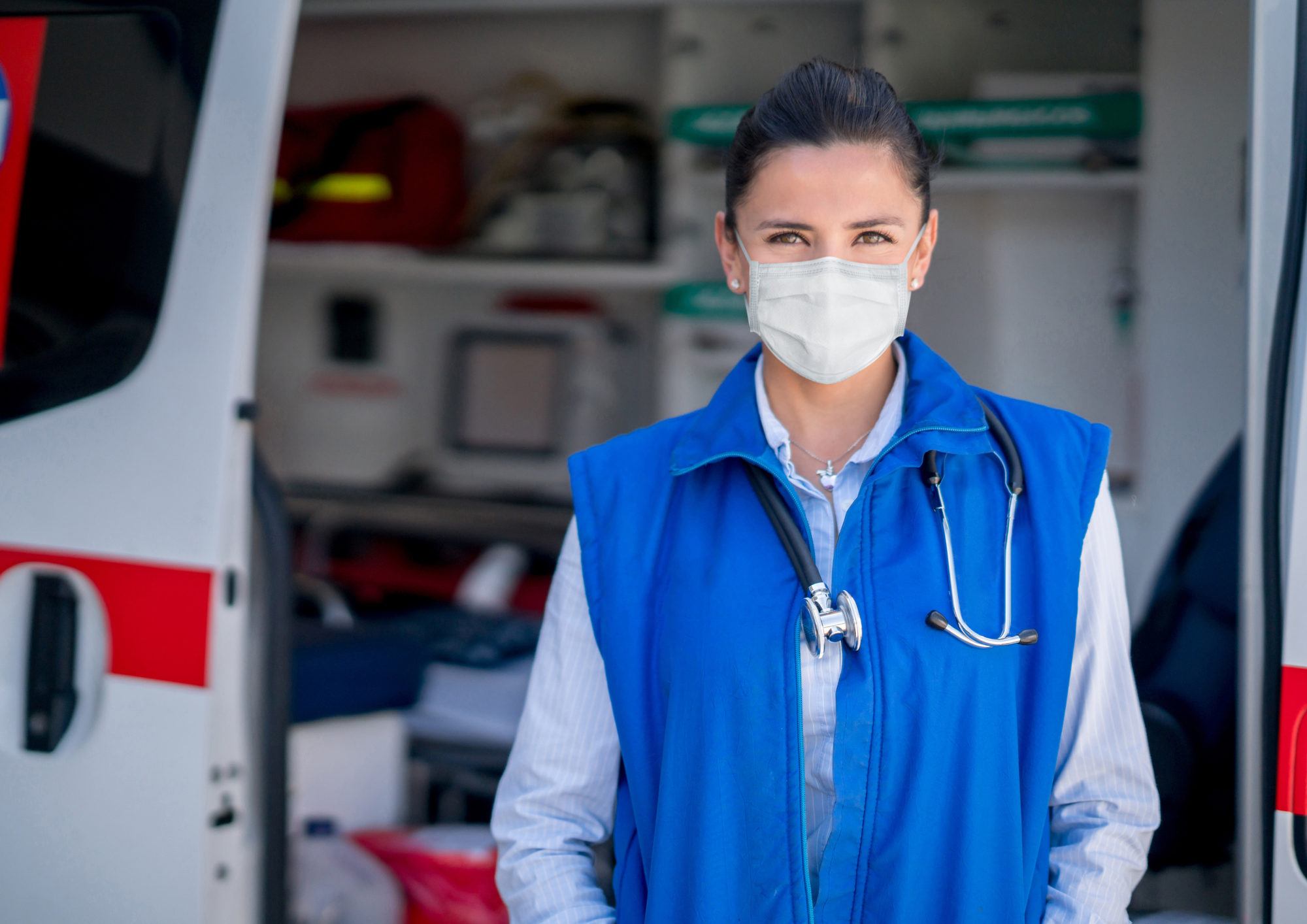 Paramedic working in an ambulance during the COVID-19 pandemic and wearing a facemask