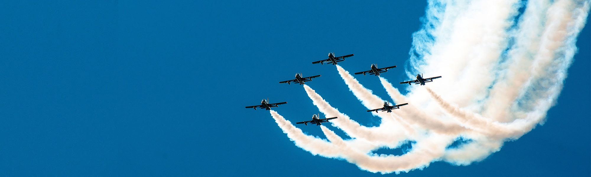 Fighter flies in the smoke in the blue sky aerobatics