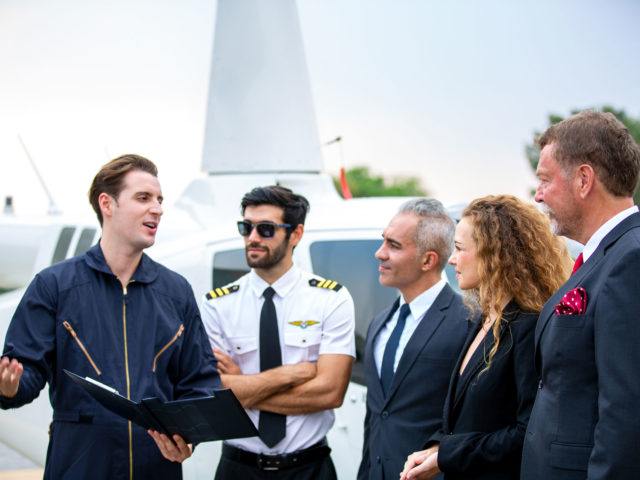 Pilot and airport staff speaking together outside