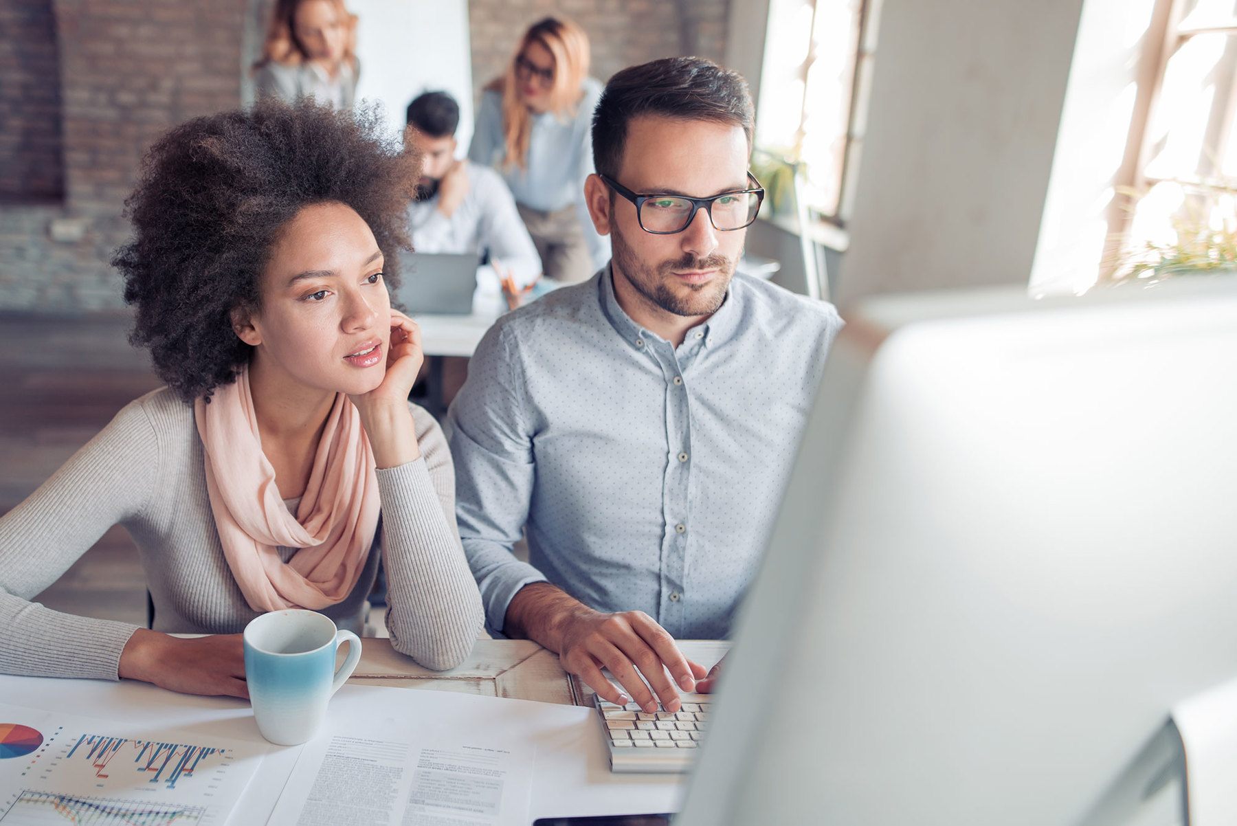 businessman and businesswoman looking at information on a computer
