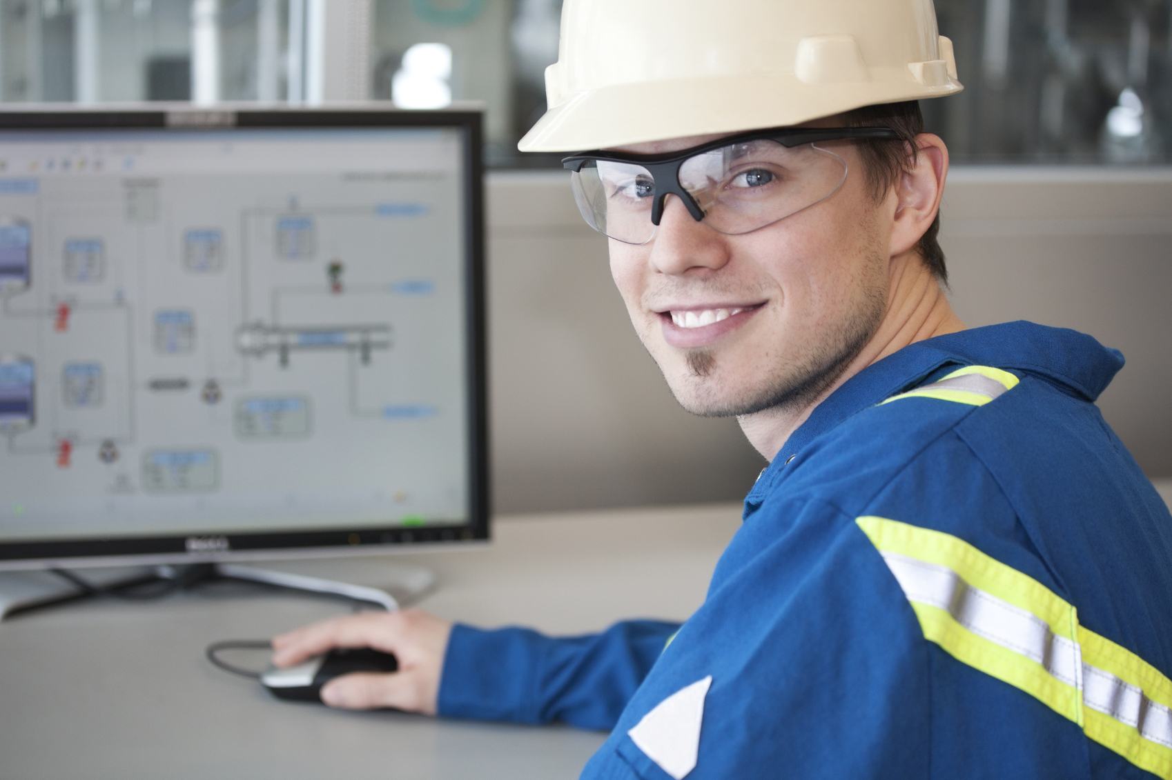 plant engineer smiling in front of computer screen