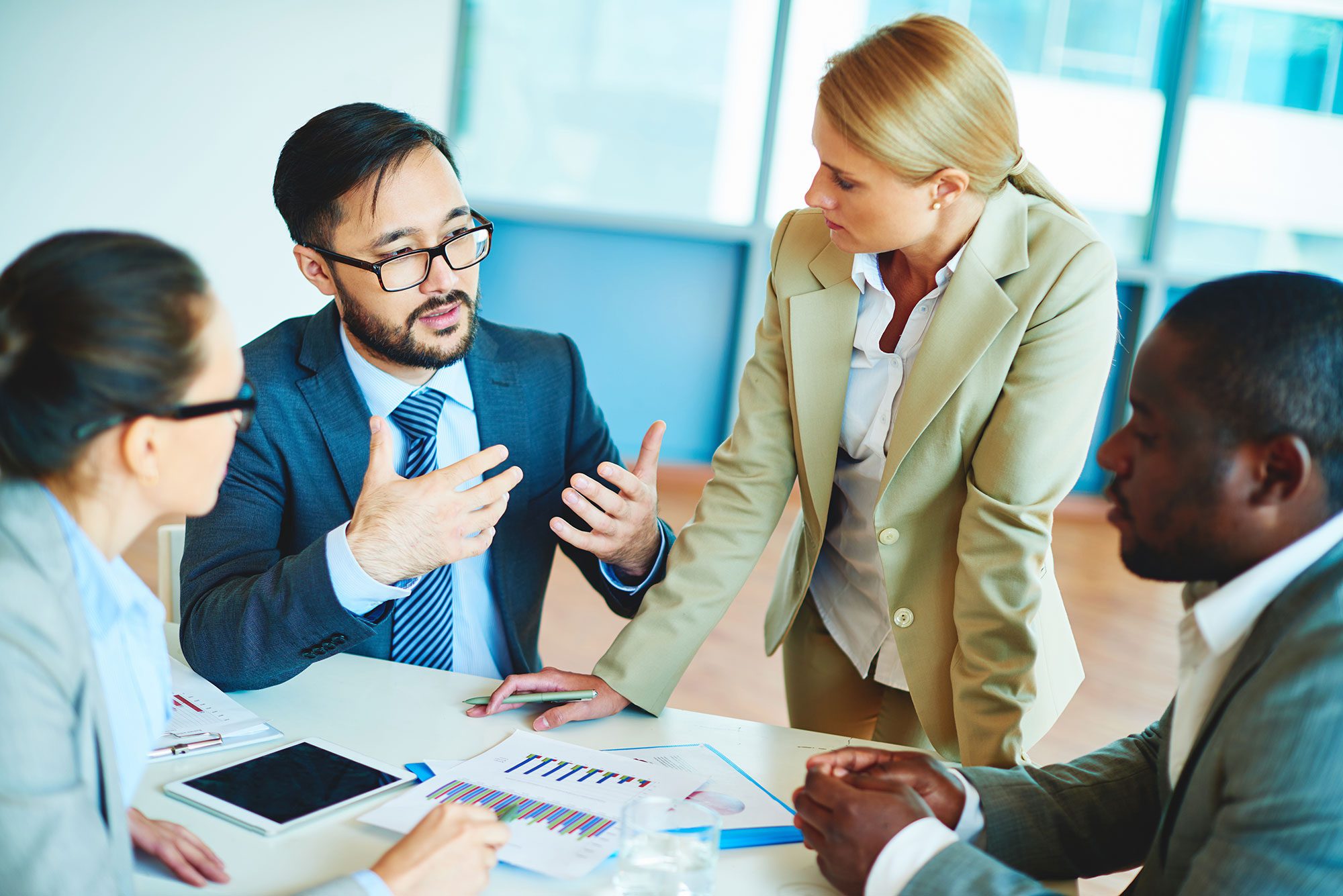 employees discussing paperwork in a meeting