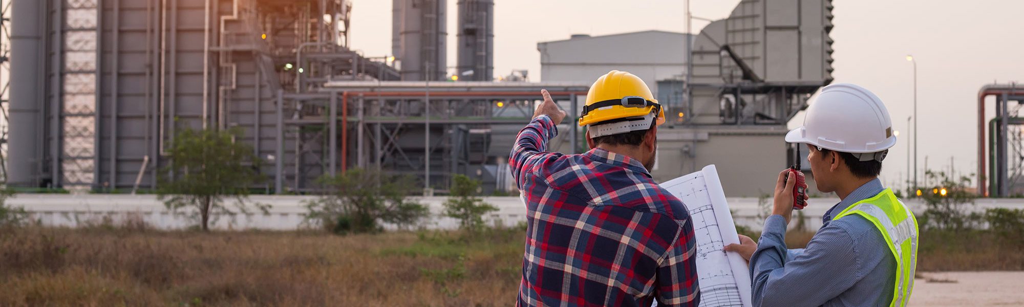 Worker and manager discussing floor plan outside energy plant