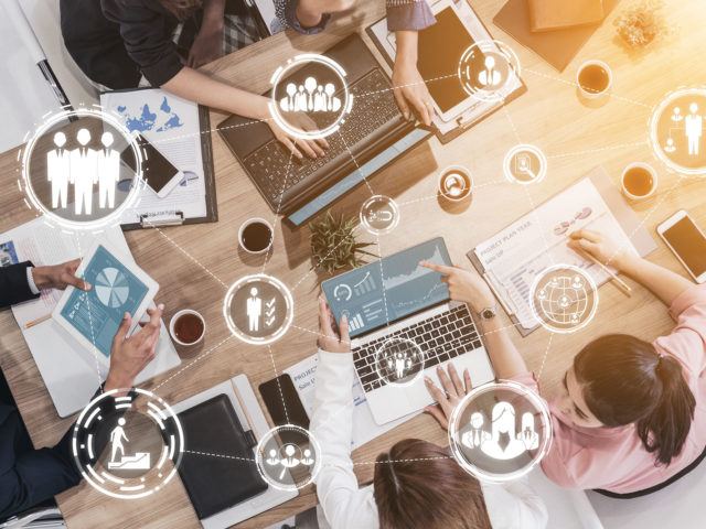 coworkers working in a shared table and VR icons overlaying