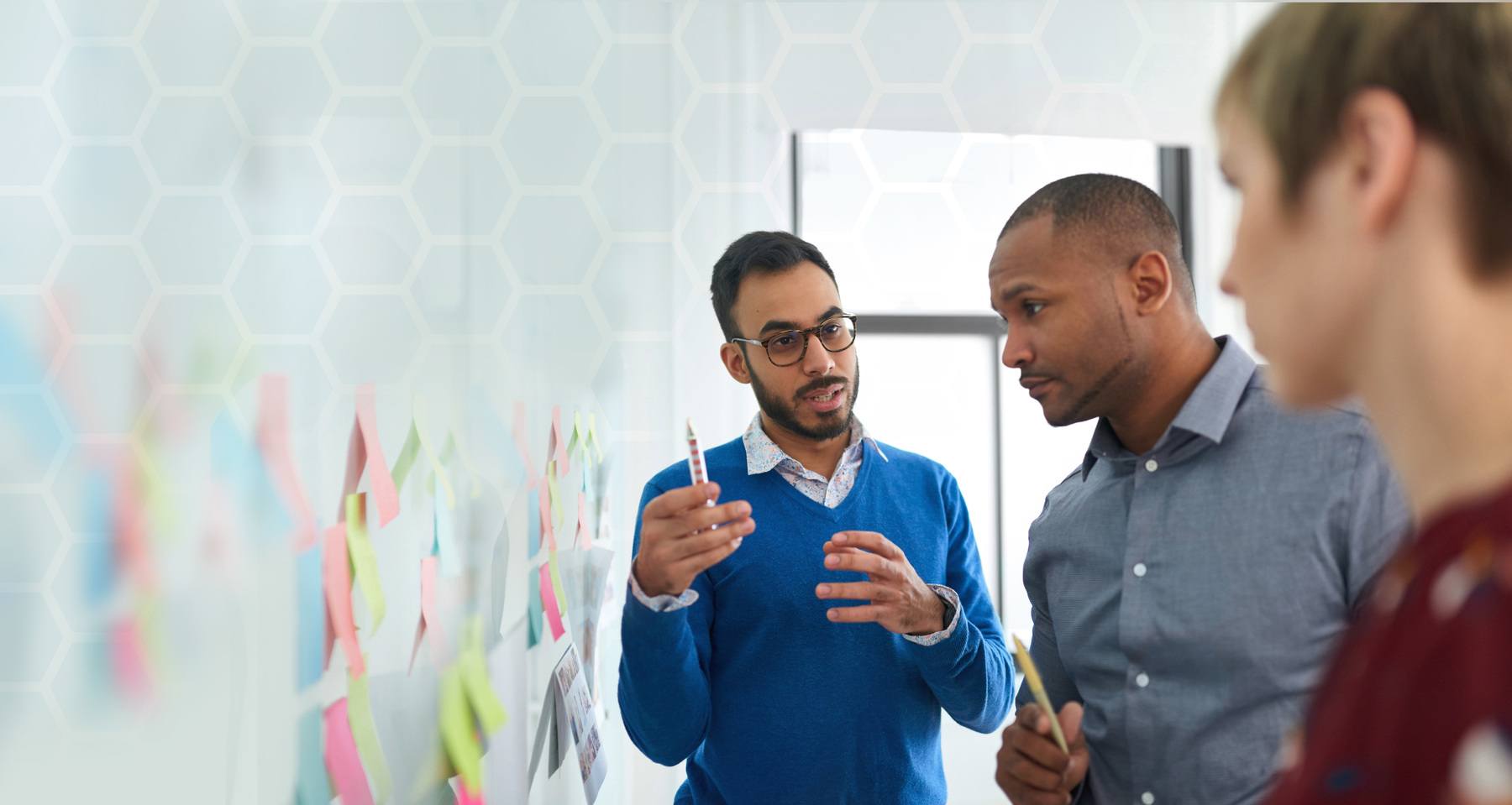 Portrait of an indian man in a diverse team of creative millennial coworkers in a startup brainstorming strategies