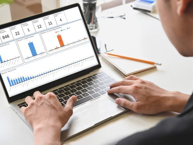 Side view man's hands using laptop computer on home office with