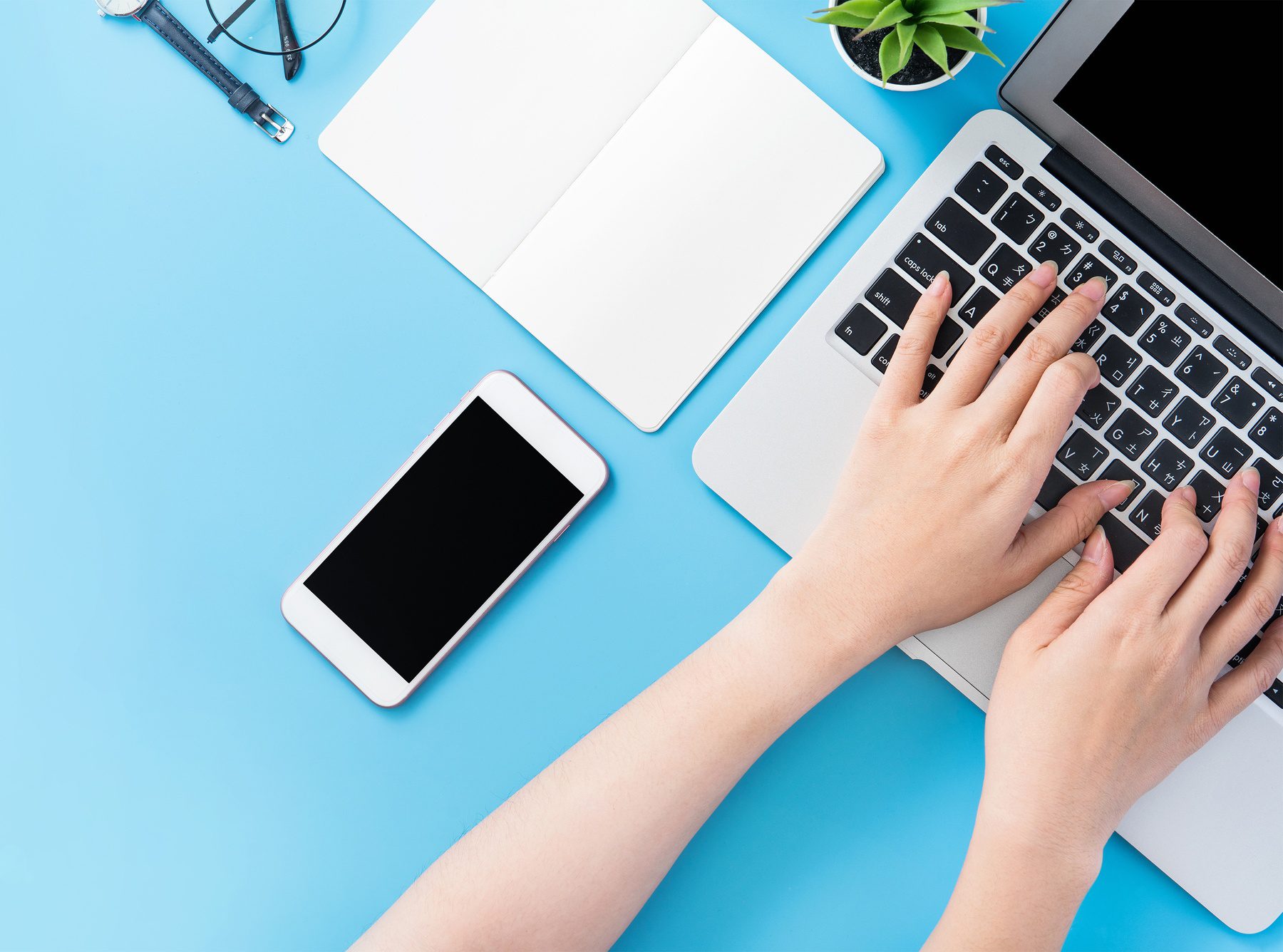Asian student surf internet for job hunting. Freelancer blog writer typing isolated on a minimal clean blue desk concept, workspace, copy space, flat lay, top view, mock up