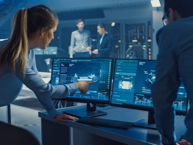 工程师们正在讨论电动概念车的 3D CAD 软件渲染