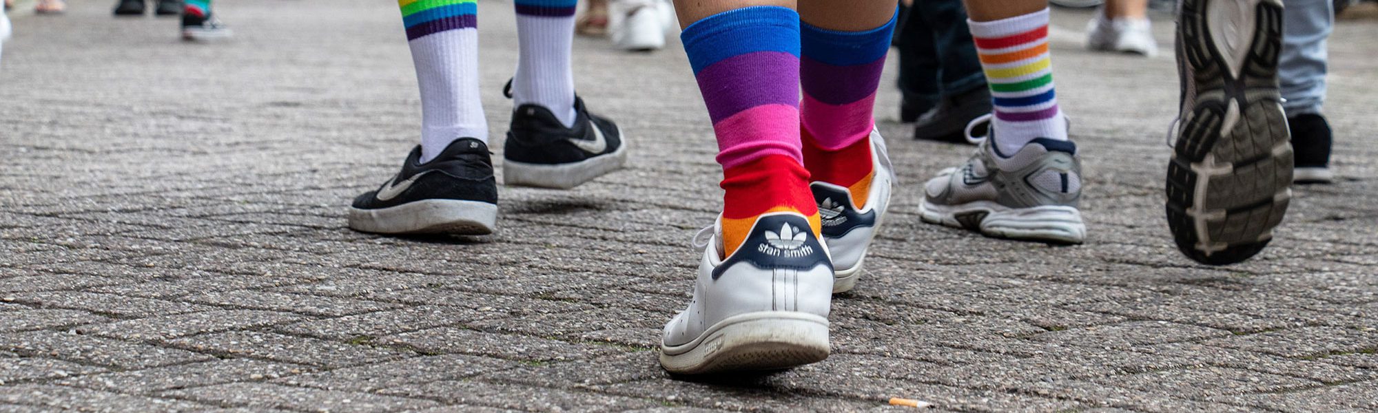 close up of people's legs wearing rainbow socks in pride parade