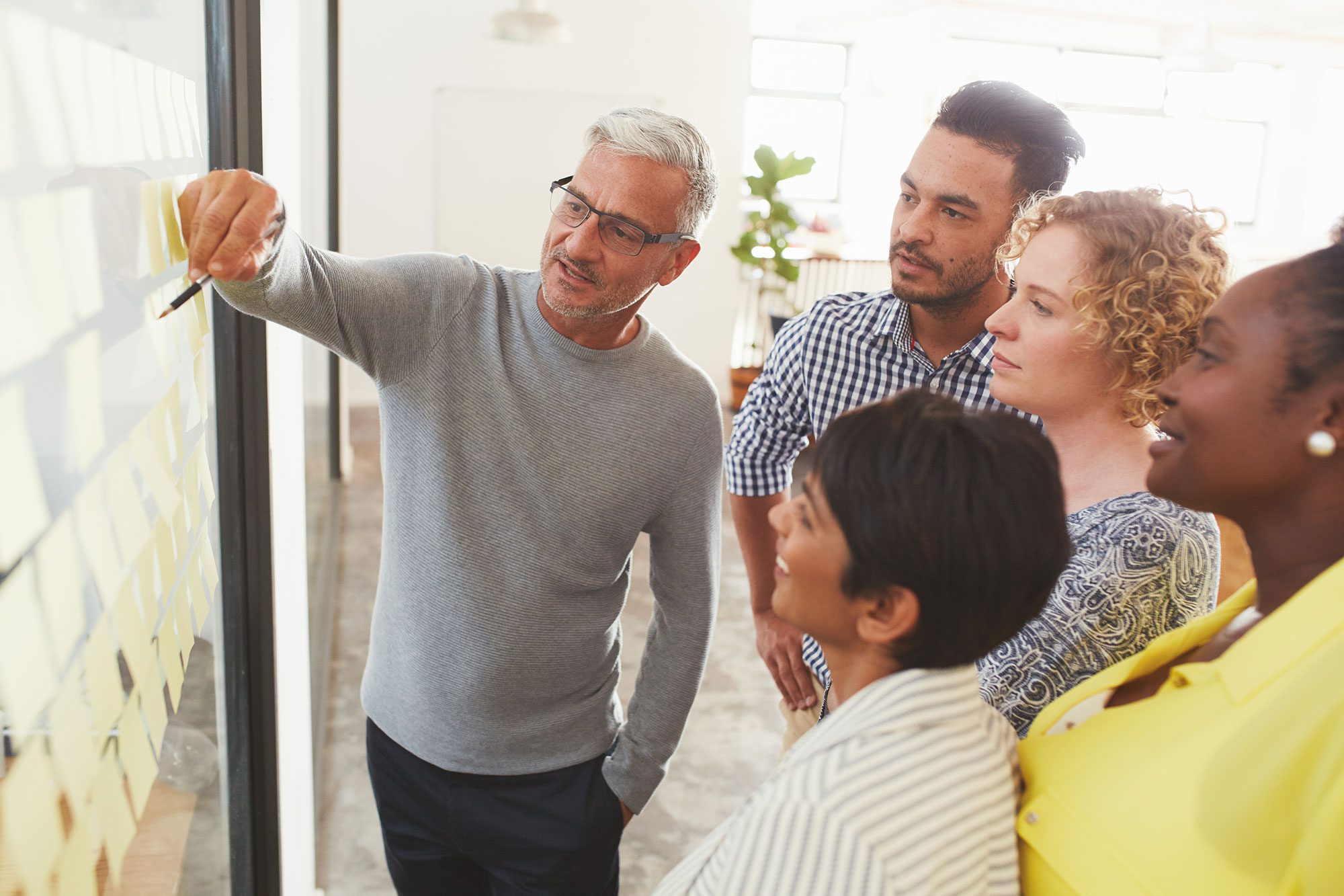 Group of diverse coworkers working on a strategy wall