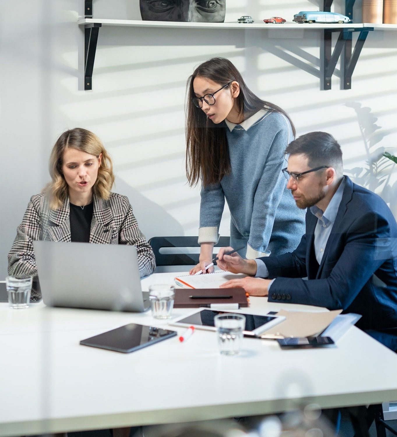 Firmentreffen in einem Büro mit 3 Mitarbeitern an einem Tisch